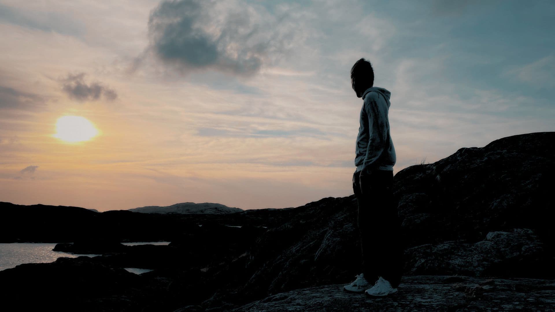Sam Polak standing on rocks during sunset